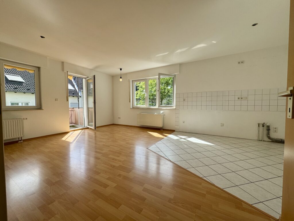 Wohnzimmer mit offener Küche  und  Zugang zum Balkon