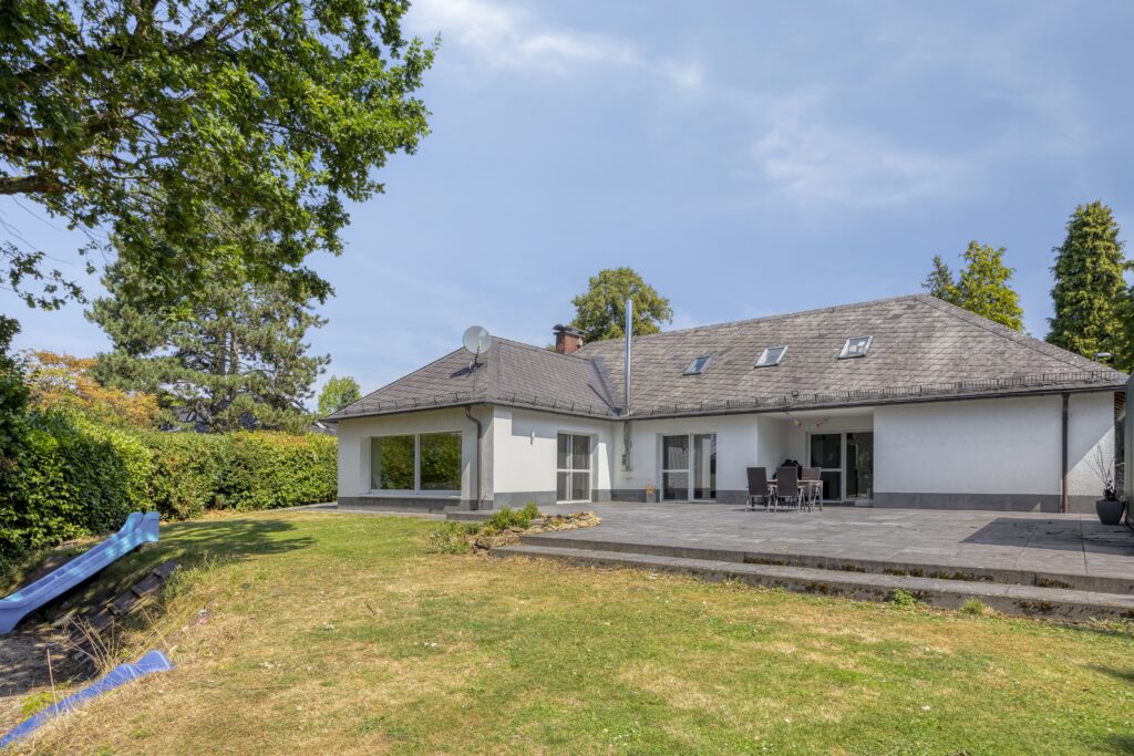 Gartenansicht des Einfamilienhauses mit großzügiger Sonnenterrasse